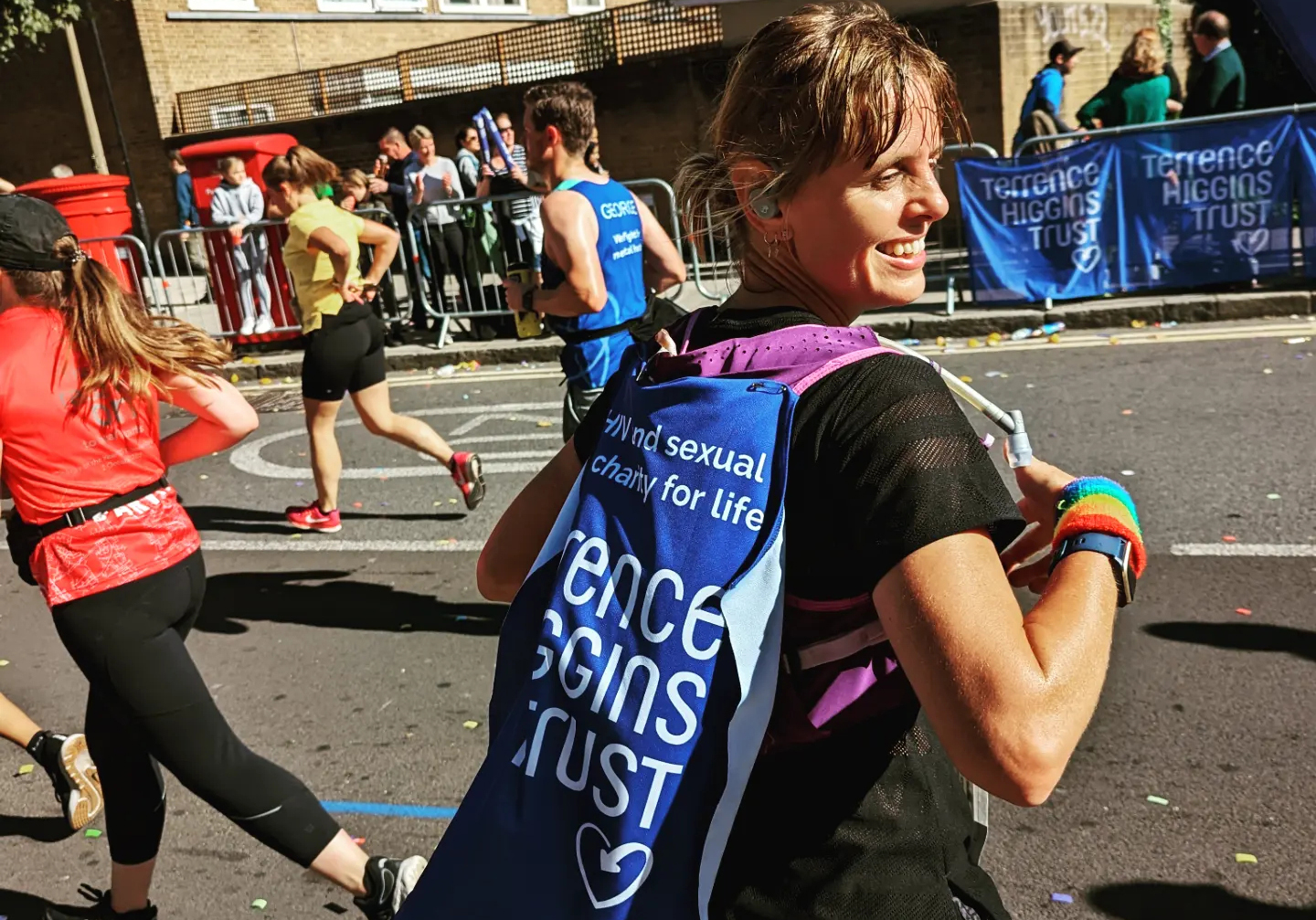 Emma running London Marathon 2022 with Terrence Higgins Trust banner on back