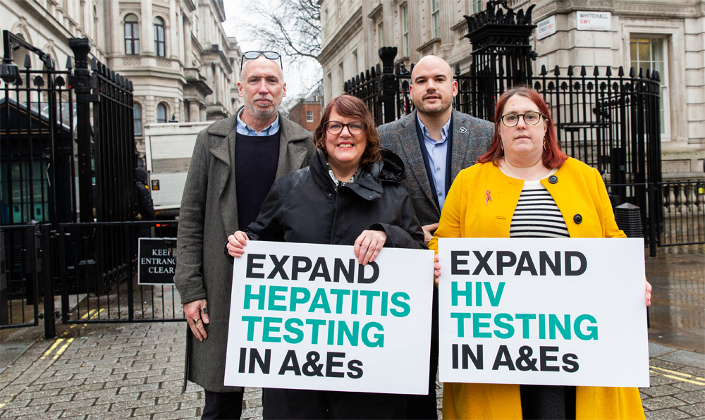 Stuart Smith, Vanessa Hebditch, Richard Angell and Deborah Gold holding signs saying 'Expand hepatitis testing in A&Es' and 'Expand HIV testing in A&Es' outside Downing Street. 