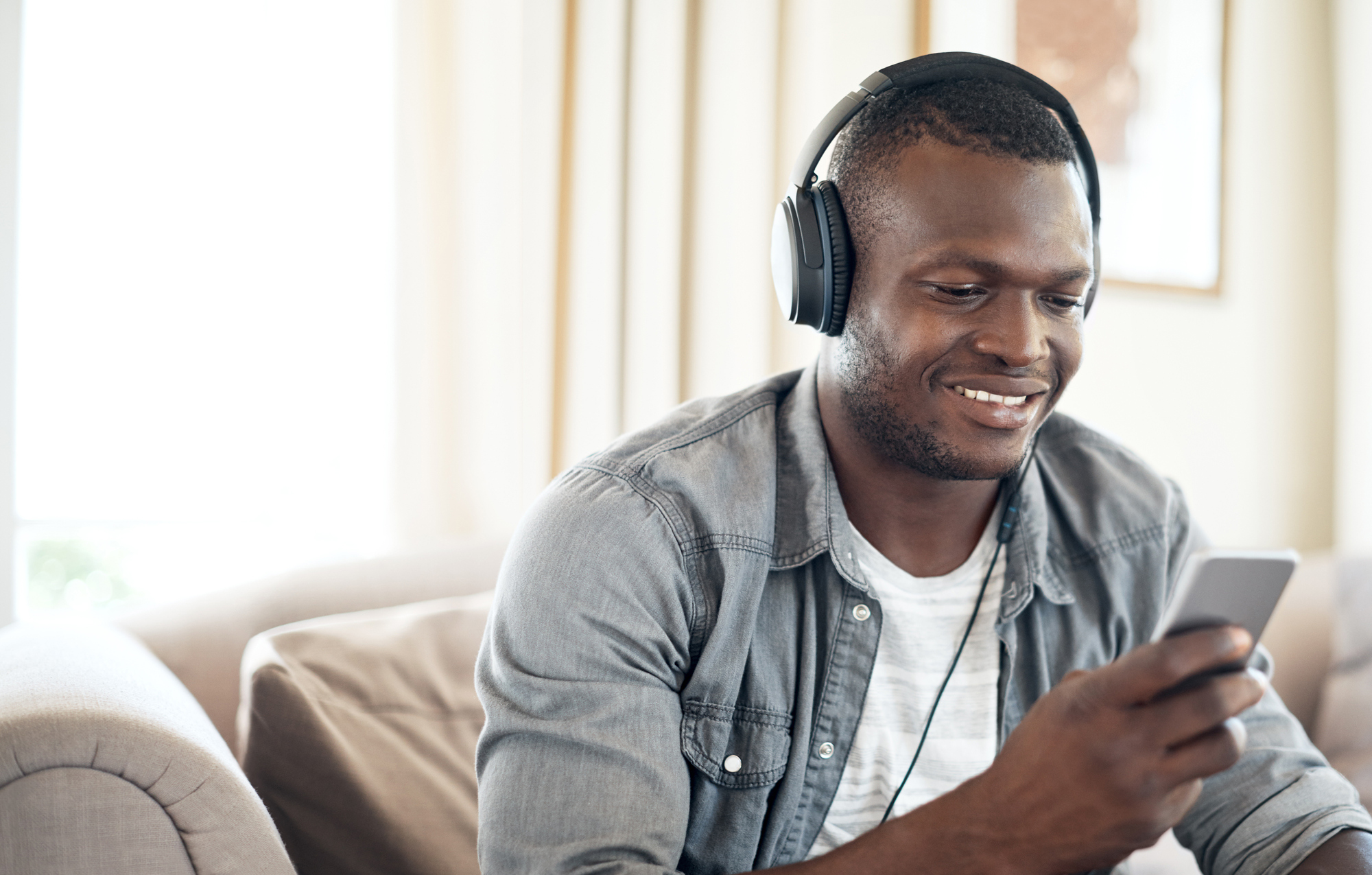 Man with headphones looking at his mobile phone