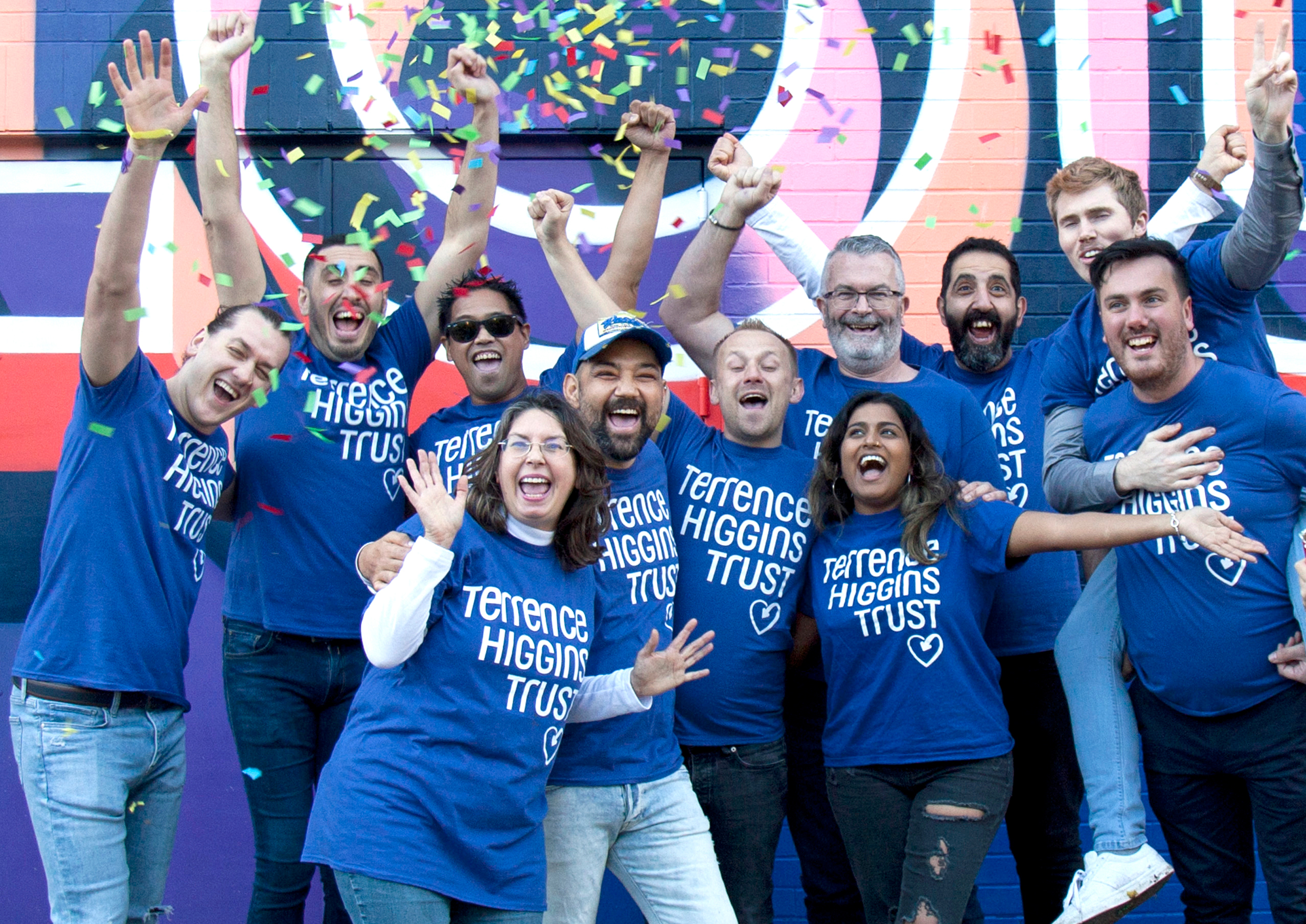 Terrence Higgins Trust celebrating group in front of wall