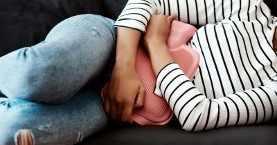 Holding hot water bottle to stomach Holding hot water bottle to stomach